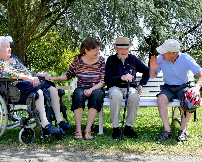 résidents et famille discutant sur un banc